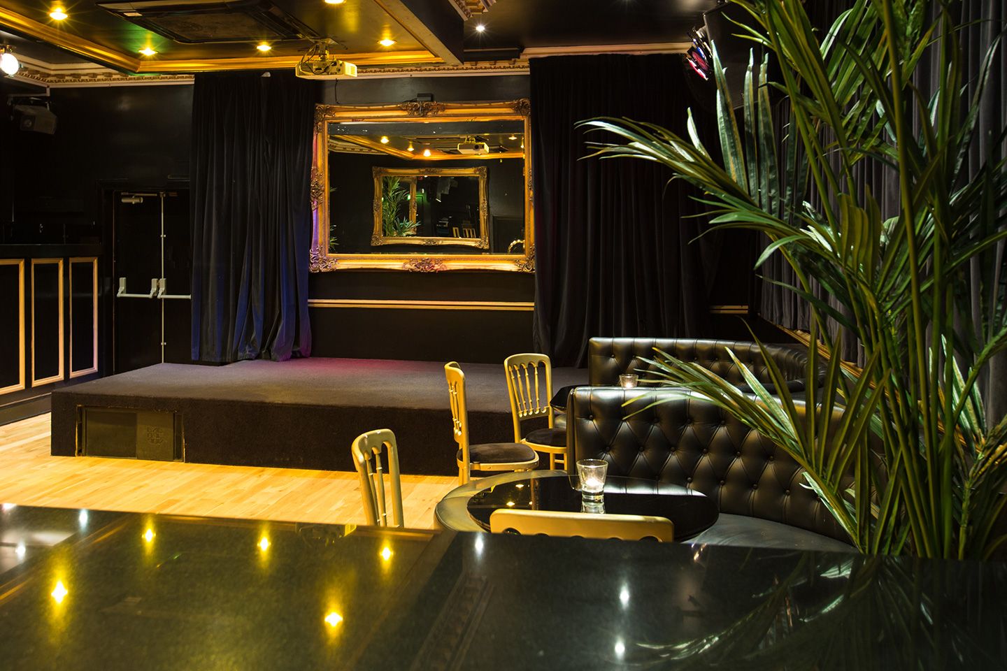 Elegant lounge with stage and plants.